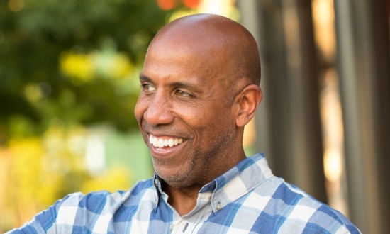 Man in plaid shirt smiling outdoors