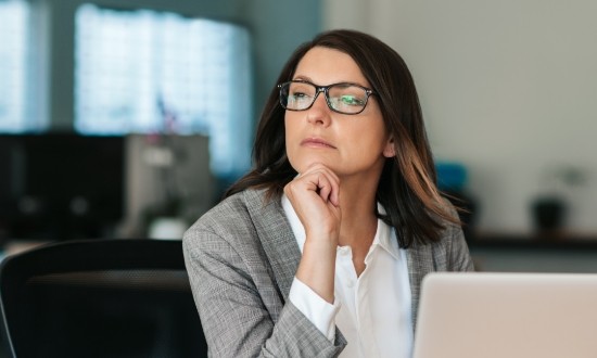 Woman sitting at table looking contemplative