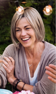 Smiling older woman in gray cardigan