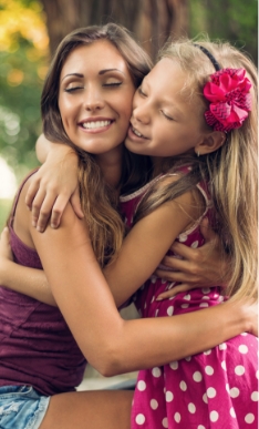 Mother hugging her daughter outdoors