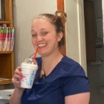 Smiling team member holding a milkshake