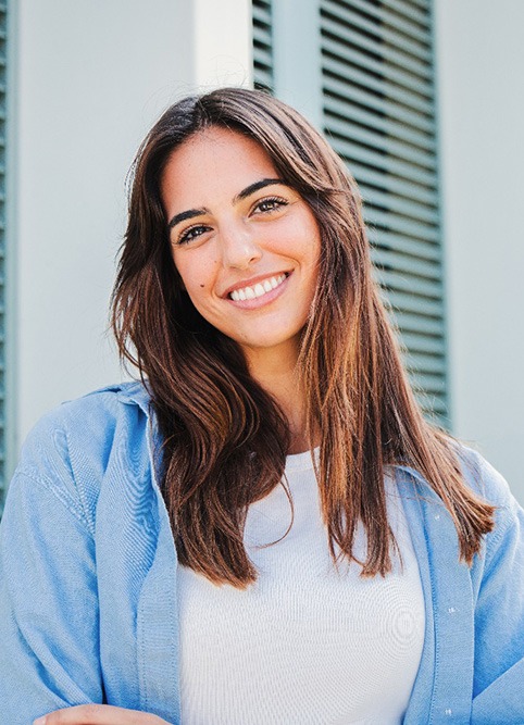 Woman with white teeth smiling while standing outside