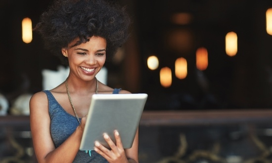 Woman smiling while using a tablet