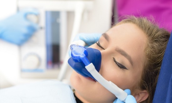 Woman in dental chair wearing nasal mask for nitrous oxide