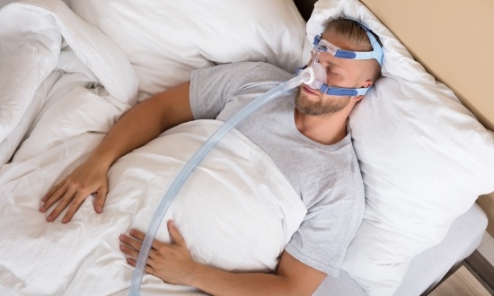 Man sleeping while wearing a C P A P mask